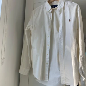 Ralph Lauren skjorta M - Fin vit skjorta från RL i strl M. Väldigt fint skick, sällan använd. Inga gula fläckar under armhålorna som ni ser.