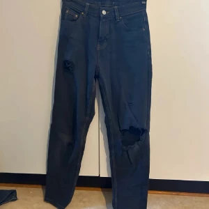 mörkblå jeans med hål - en gång i tiden har de varit ljusblå men har färgat med svart textilfräg så de blivit väldigt mörkblå. snygg baggy look som slutar smalt längst ner, kan sitta ganska lågmidjat. storlek ör bara en gissning, fråga om exakt så kollar jag!