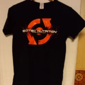 Svart t-shirt från Gildan med Scitec Nutrition-tryck - Säljer en svart t-shirt från Gildan i bomull med ett stort, rött Scitec Nutrition-tryck på framsidan och mindre tryck på baksidan. Perfekt för träning eller vardagsbruk.