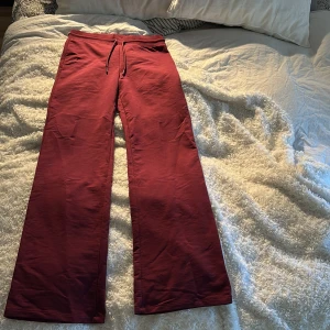 Vinröda mjukisbyxor med snörning - Säljer ett par vinröda mjukisbyxor med snörning i midjan. Byxorna har en loose passform och är perfekta för en avslappnad stil. De är tillverkade i ett mjukt material som ger en bekväm känsla.