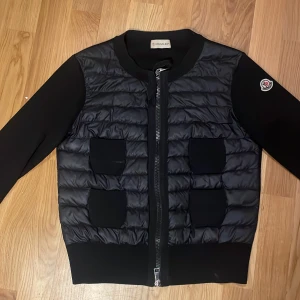 Svart jacka från Moncler - Snygg svart dam jacka/kofta från Moncler i storlek xs. Säljer den då den är för liten. Den är jättefin men två styng har låsnat i nacken, syns ej om man inte är jätte nära.