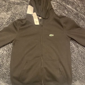 Lacoste hoodie black - Säljer en snygg lacoste hoodie på grund av att de inte passar mig. För kvinnorna är det storlek M och för män det är XS/S. Materialet är mycket tjockare än vad den ser ut att vara på bilden, om du är intresserad för flera bilder det är bara höra av sig, jag kan alltid komma upp med ett bättre pris!