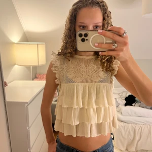 Beige volangtopp med spetsdetaljer från Zara - Säljer denna snygga beige toppen med volanger och spetsdetaljer😍😍Den är i så fin både till skolan och till fester💕