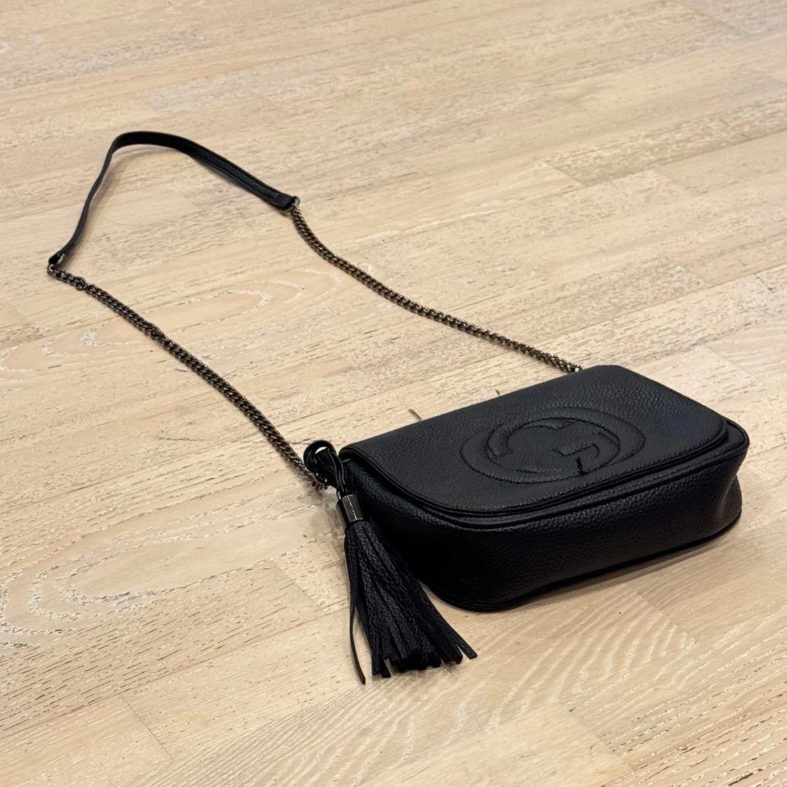 Svart axelväska med tofsdetalj