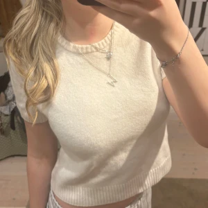 Beige kortärmad tröja från Zara - Säljer en stilren beige tröja från Zara med korta ärmar och ribbade detaljer vid ärmslut och nederkant. Den är i nyskick och endast använd 2 gånger. Den är i storlek M men råkat tvätt den för varmt så den sitter mer som en S/XS🌟🤍🫶🏻