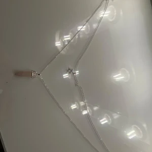Silverhalsband med stjärna och rosa sten - Elegant silverhalsband med en liten stjärna och en hängande rosa sten. Längden är justerbar och köpt för 200kr! Halsbandet är aldrig använt och är då i mycket bra skick!