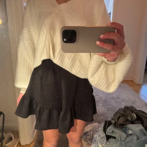 Svart kortkjol med volang - Snygg svart kortkjol med volangdetaljer. . Kjolen har en bekväm passform och är lätt att matcha med olika toppar.