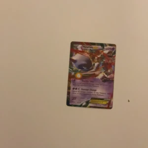 Pokémonkort med Mewtwo - Säljer ett Pokémonkort med Mewtwo. Kortet har en färgglad design med Mewtwo i fokus och texten 'Damage Change'. Baksidan har den klassiska blå designen med en Pokéball i mitten.