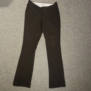 Svarta kostymbyxor från Neo Noir - Snygga svarta kostymbyxor från Neo Noir, medelhög midja. Fin passform och lite utsvängda längst nere. med en elegant och stilren design. Byxorna är lite noppriga vid midjan men det kan tas bort eller täckas över 😍🥰🫶🏼