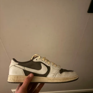 Travis Scott Air Jordan 1 OG Reverse Mocha låga sneakers - Snygga Nike sneakers i vitt och brunt med klassisk snörning. Du får även med boxen till, leverans inom 1-2 dagar