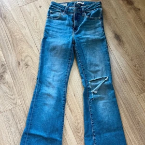 Levi's 726 Flare Jeans - Snygga Levi's 726 Flare jeans i blå denim med en slitning på ena benet. Dem är sparsamt använda.