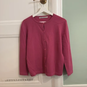 Rosa lila  kofta från Westerlind Design - Säljer en söt rosa kofta från Westerlind Design. Den har långa ärmar och knappar framtill. Perfekt för att lägga till en färgklick i garderoben! Står ingen storlek men skulle säga S.