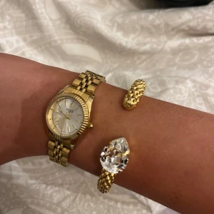 Guldfärgad tunnklocka  - Elegant guldfärgad klocka med en klassisk länkarmband och vit urtavla. Klockan har en tidlös design som passar perfekt för både vardag och speciella tillfällen. Batteriet funkar ej, har kvitto med garanti, gratis länkbyte på ur&penn🤍