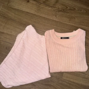 Ljusrosa kabelstickat  - En ljusrosa kabelstickad långärmad tröja och en kabelstickad poncho 