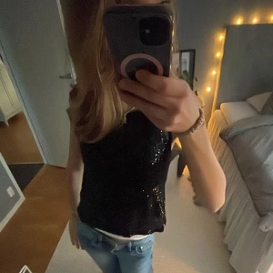 Svart paljettopp från Zara - Snygg svart ärmlös topp från Zara täckt med glittriga paljetter. Perfekt för en festlig look. Storlek 152 men passar mig som har xs/s. Skriv till mig innan ni trycker på köp! 💞💞