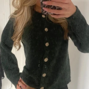 Mörkgrön stickad kofta - Säljer min mörkgröna kofta från vila med sååå fina knappar. Säljs då den inte kommit till användning. Ny utan prislapp så i väldigt bra skick☺️