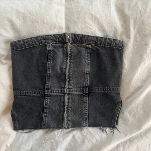 Svart jeanskorsett från Zara - Snygg svart jeanskorsett från Zara med dragkedja fram och elastisk smockdetalj bak. Använd fåtal gånger, bra skick och passar XS-S