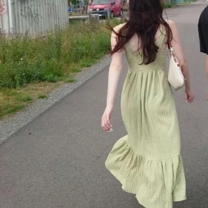 Grön midi klänning med rutigt mönster - Snygg grön långklänning med ett diskret rutigt mönster. Klänningen har breda axelband och en volangdetalj vid fållen. Perfekt för en somrig dag!