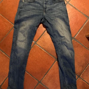 Blå slim jeans från G-Star RAW - Snygga blå slim jeans från G-Star RAW, modell 3301. Klassisk design med fem fickor och en bekväm passform. Perfekta för en stilren look.