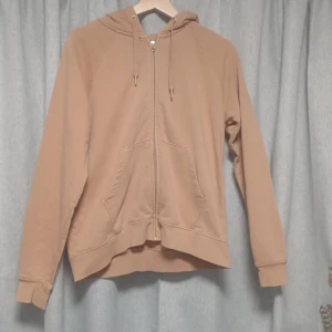 Brun zip hoodie - En ljusbrun hoodie med dragkedja. Den har en bekväm luva med snören i