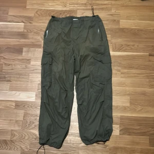Olivgröna tunna cargobyxor - Storleken är 30 | 32, sköna byxor åt dom som gillar streetwear, tror att en av justeringarna på midjan är lite trasig men annars märker man inget fel.