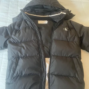 Calvin Klein Jacka - Säljer en varm och snygg Calvin Klein Jacka i storlek S. Den köptes förra vintern och är hyfsat använd. Inga hål eller defekter på jackan och är i gott skick. Nypris: 2700 på Calvin Kleins hemsida.