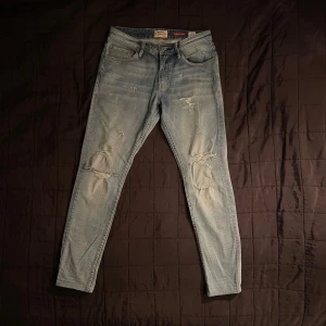 Crocker Jeans - Säljer mina Crocker jeans med dess feta slitningar. Det svenska märket Crocker finns inte kvar och det gör dem här jeansen extra unika! Storleken är 30/32. De har inga defekter. Modellen är slim fit. Hör av dig vid fler frågor!
