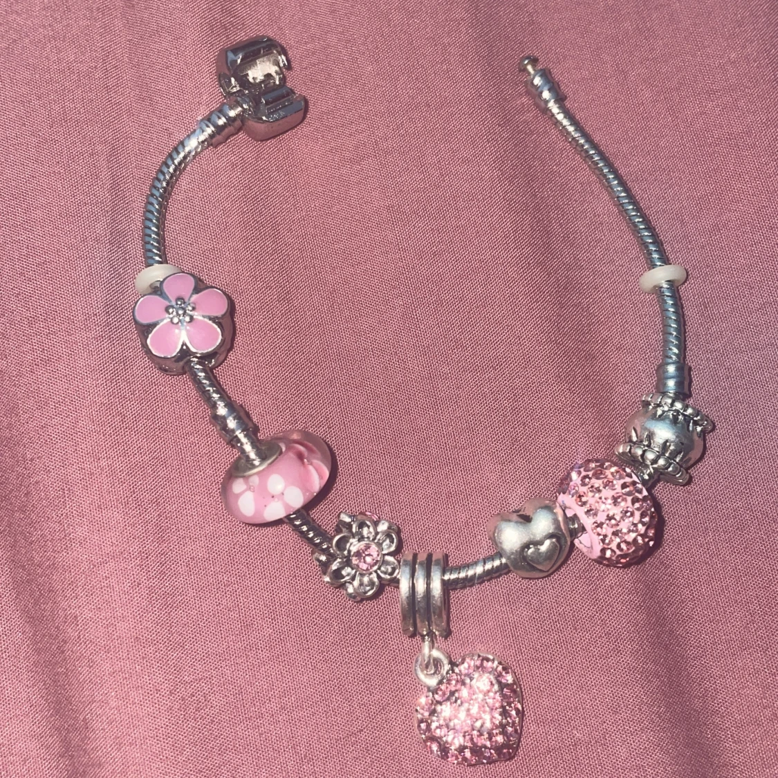 Charmigt armband med rosa detaljer - 1