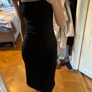 Långklänning  - Svart ribbad långklänning från H&M med knytning i ryggen. Endast använd ett fåtal gånger så fint skick