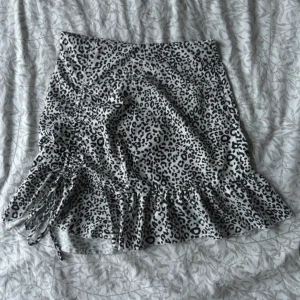 Vit leopard kjol - Kjol med Vit/Svart leopardmönster. Knytning nere och sedan så finns det en dragkedja på sidan😇 Bra skick