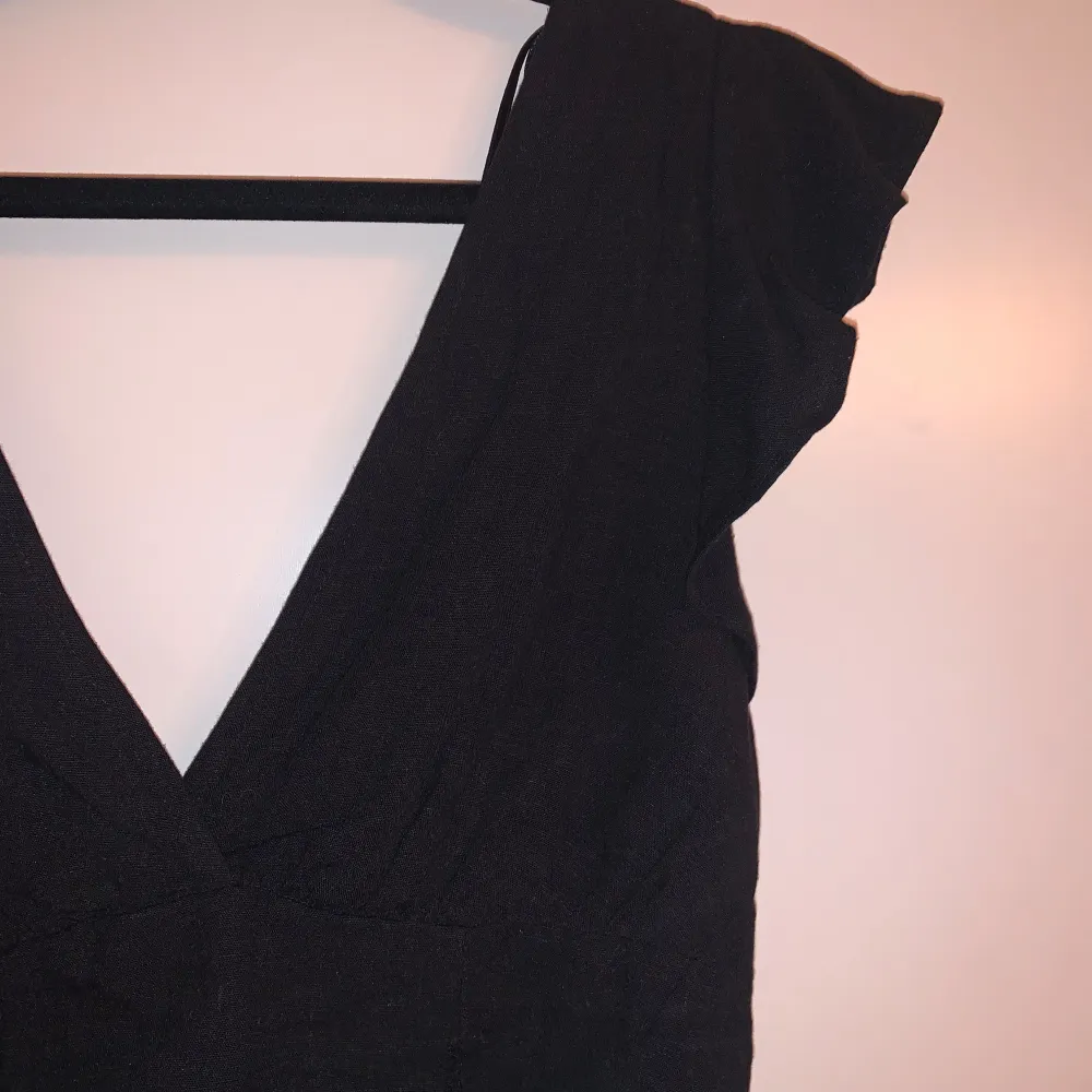 Säljer en snygg svart topp med korta ärmar och en djup v-ringning. Toppen är croppad och har en stilren design. Från Pull&Bear i storlek M. Aldrig använd . Yläosat.