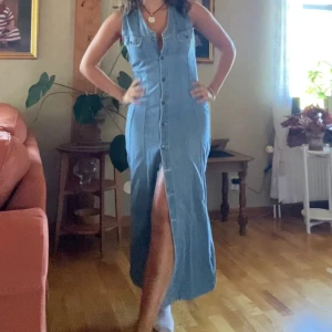 Jeansklänning  - Mycket snygg ärmlös Jeansklänning som är insydd i sidorna för passform för personer ca 50-60 kg , hon på bilden är ca 170cm ganska smal. Klänningen är annars i stl L och kan tas ut igen eftersom tyget finns kvar inunder. 