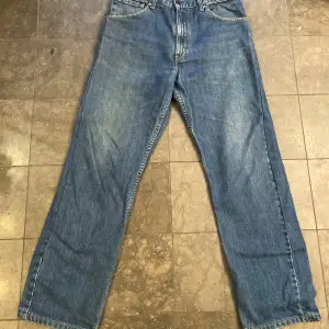 Säljer ett par klassiska Levi's 521 jeans i blå denim. De har en straight passform och är i bra skick. Står 36 men har sytt in dem så att de passar en 32.