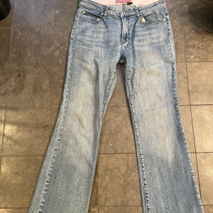 Blå bootcut jeans - Säljer ett par klassiska blå bootcut jeans i en ljus tvätt. De har en snygg och avslappnad stil med en bekväm passform.