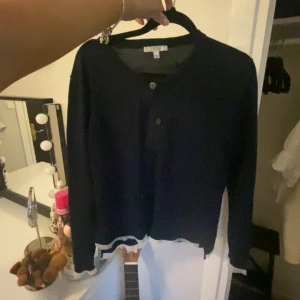 Dagmar kofta - Mörkblå kofta med knappar från Dagmar med volanger vid bla ärmarna.