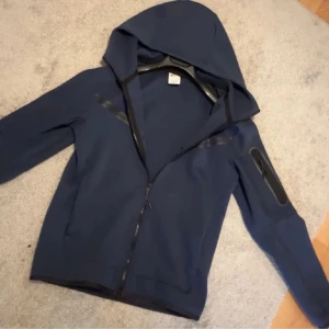 Nike tech navy blue - Hej säljer denna snygga nike tech i size S. Färgen är navy blue och skick 10/10. Köpt för 1200kr. Säljer billigt för att jag vill bli av med den snabbt. 