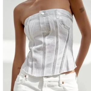 Vit korsett topp i jeanstyg - Snygg vit tubtopp i jeansstil med silver detaljer. Toppen har en korsettliknande design med sömmar som ger en strukturerad look. Perfekt för en trendig och stilren outfit. Dragkedja på baksidan med ribbat tyg vilket gör att den passar både Xs och S. Få upplagor skapade (svår att få tag i) samt i toppen kvalitet då jag inte fann tillfällen att använda den, därav priset. Nypris 499kr från Zara. Skriv för frågor eller om pris så kommer vi nog överens om något 💕