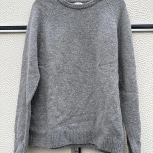 Grå ulltröja från Zara - Säljer en stilren grå ulltröja från Zara. Tröjan har en klassisk design med långa ärmar och ribbade kanter vid ärmslut och nederkant. Perfekt för kyligare dagar. Passar mer S 