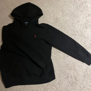 Svart hoodie från Ralph Lauren i XL i barn storlek  - Svart Ralph luaren hoddie storlek XL (I barn storlek!) i vuxen storlek så är den XS till S passar 170-180, skön och avslappnad tröja. Skick 9/10 inga skador på tröjan. Skriv vid intresse💯