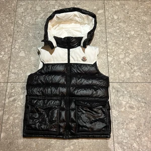 Dunväst från Moncler - Tja! säljer min Moncler väst. Den har blivit för liten för mig. Köpte den i London och den kommer med kvitto och dustbag. avtagbar huva. Perfekt för kyligare dagar när du vill hålla stilen. Priset är inte hugget i sten! Skicka dm om frågor eller mer bilder.
