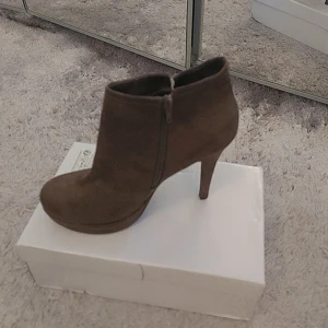 Bruna mocka boots med klack - Snygga bruna boots i mocka från Benetton med dragkedja på sidan. De har en elegant klack och är perfekta för att ge en stilren touch till din outfit.