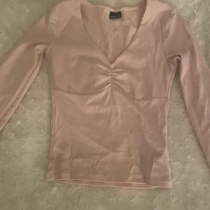 Rosa v-ringad topp - Säljer en söt rosa topp med v-ringning och rynkdetalj framtill. Bra skick, pris går att diskutera vid snabb affär💗