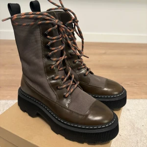 LÄST Caroline  Vinter stövlar från märket 38 passar  39  - LÄST Caroline  Vinter stövlar från märket 38 passar  39 ( innersula storlek 24,5 cm) använt 1 gång. Nypris 3400 kr LÄST – Caroline LÄDER/TEXTILOLIV, VARMT FODER Chunky klassisk hög snörstövel med metallöglor och krokar för spetssnöre. Kvaliteten är 100 % koläder och PES-textil. Yttersula i EVA med dubbel passform och sömmar och märkt med LÄST-logga nedtill. Dessa stövlar är varmfodrade.