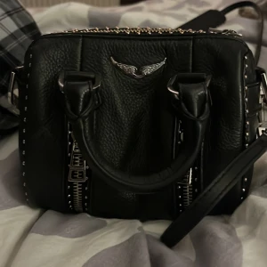 Zadig Voltaire väska  - Säljer den här fina Zadig väskan i model sanny xxs använd 1 gång köpte den för 3500 säljer den för 2500 och jag står för frakt kan kan gå Max gå ner till 2000 vid snabb affär OBS byter inte väskan mot nåt  säljer den då jag köpte den mest som prydnad kan även mötas upp i Stockholm 