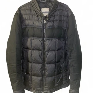 Svart quiltad jacka från Moncler - Snygg svart quiltad jacka från Moncler med dragkedja framtill. Jackan har långa ärmar och en stilren design med Moncler-logga på ärmen. Perfekt för kyligare dagar.