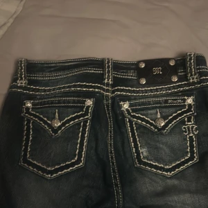 Blåa  jeans med vita sömmar från Miss Me - Snygga blåa  jeans från Miss Me med kontrasterande vita sömmar och dekorativa knappar. Strl 30, kom privat för bilder på