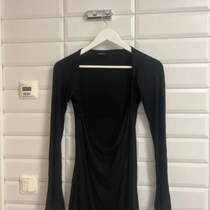 Svart klänning från Gina Tricot storlek:L  - Snygg svart klänning från Gina Tricot med långa ärmar och en stilren design. Perfekt för en elegant look. Klänningen har en draperad detalj framtill som ger en extra touch. Aldrig använd. Säljer för 95 kronor. 