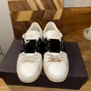 Valentino Garavani Rockstud Untitled Sneakers - Valentino Garavani Rockstud Untitled Sneakers i glansig svart rem i storlek 42,5. Box, dustbag och nya snören medföljer