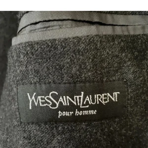 YSL Rock  - Snygg grå rock från Yves Saint Laurent pour homme. Klassisk design med två knappar framtill och fickor. Perfekt för en stilren look. Är i storlek 50 viker motsvarar S. Lite kort i armarna men den ska va så.
