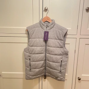Helt Ny Ralph Lauren Purple Label Väst – Storlek M, Med Prislapp - Ralph Lauren Purple Label väst i storlek M, en tidlös och exklusiv design från Ralph Laurens mest prestigefyllda kollektion. Västen har en mjuk och lyxig känsla i materialet med en kombo av stil och komfort.   Plagget är i nyskick och har inte kommit till användning, vilket är anledningen till att jag nu säljer den vidare. En idealisk investering för garderoben, vare sig det är för en avslappnad eller uppklädd look.  Gör ett kap med ett klassiskt plagg från Ralph Lauren Purple Label.  